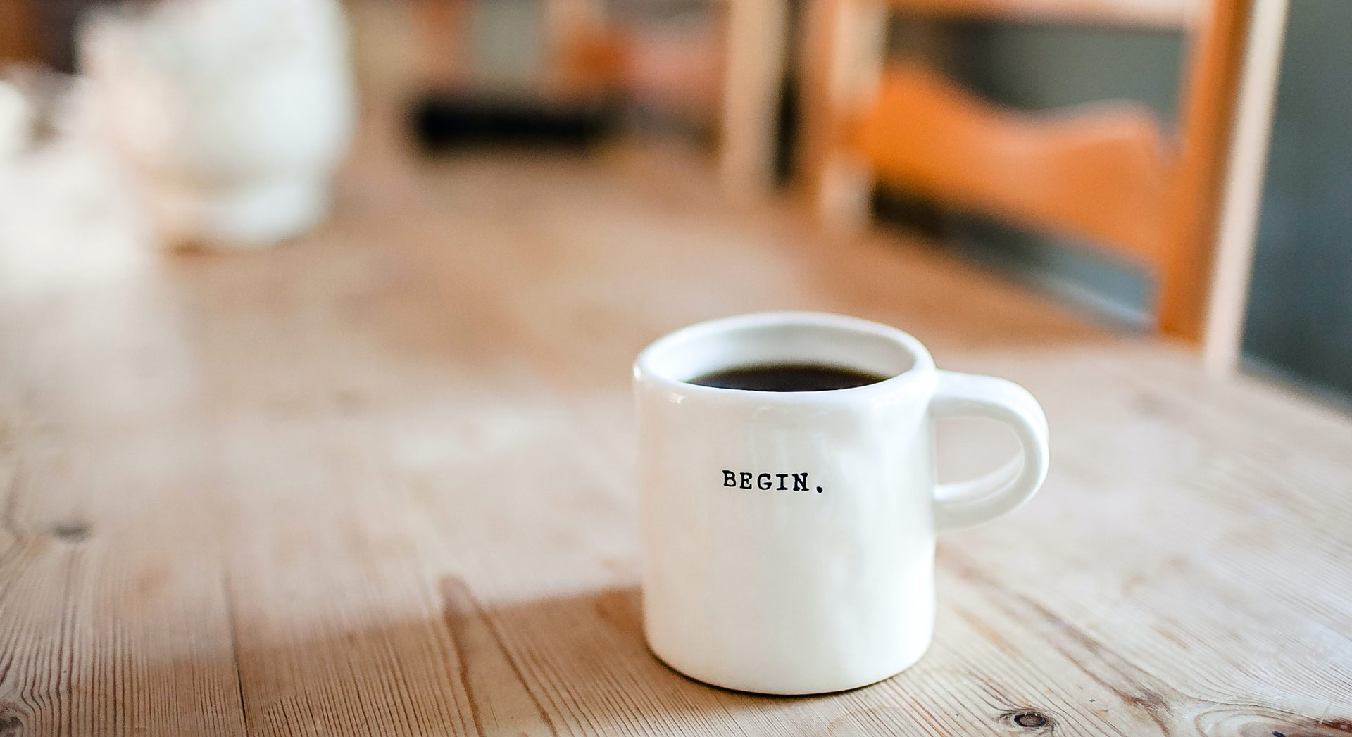 Taza de café con la palabra -begin- impresa.