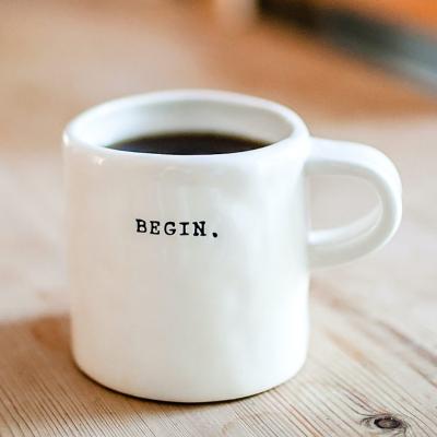 Taza de café con la palabra -begin- impresa.